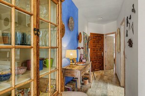 A hallway with a wooden cabinet, a table with a lamp, and a door. - Holiday Apartment 'Casa Sherazad' with Sea View, Private Terrace and Wi-Fi (Tías)