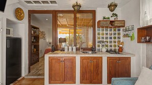 Una cocina con armarios de madera, una isla central, un lavamanos y una estufa.