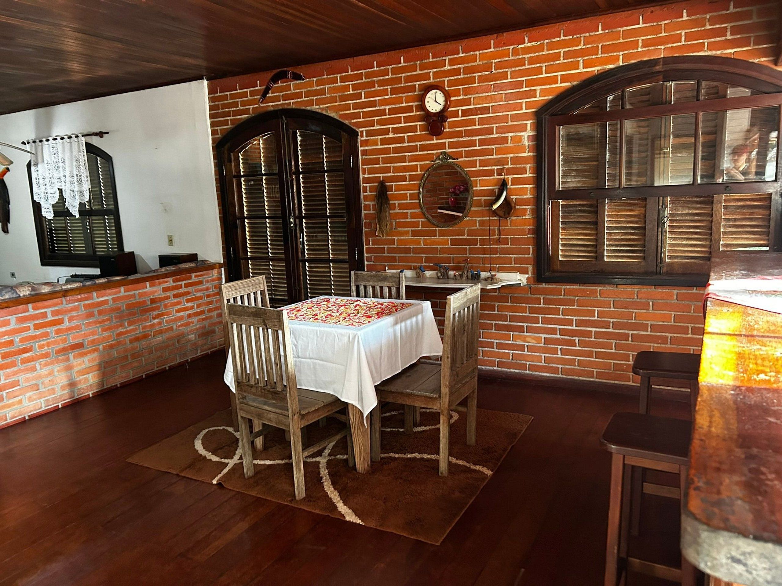 A dining area with a brick wall, wooden furniture, and a white tablecloth.