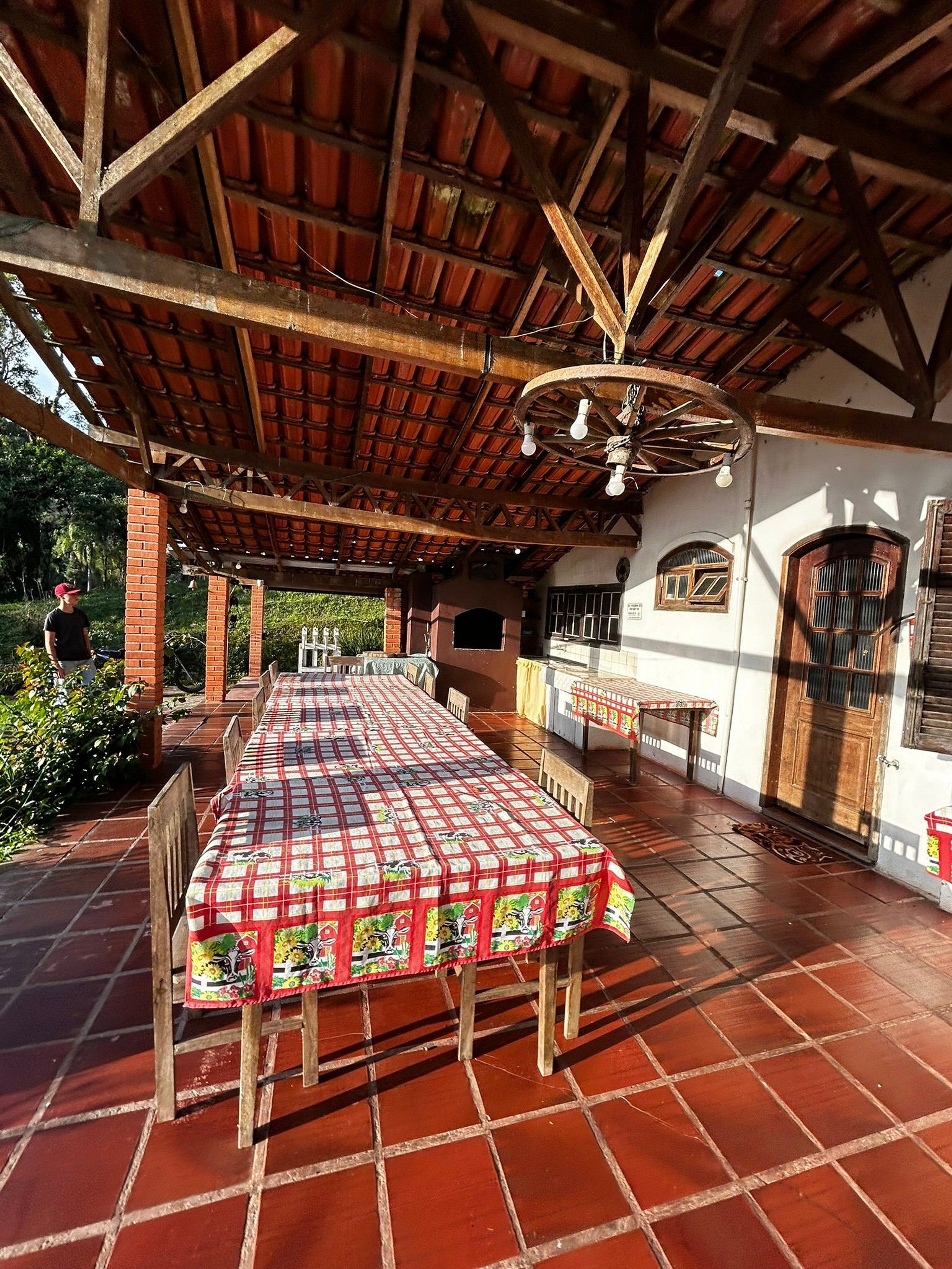 An outdoor patio with a covered dining area, a brick wall, and a traditional wooden ceiling.