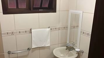 Une salle de bain avec des toilettes, un lavabo et un miroir.