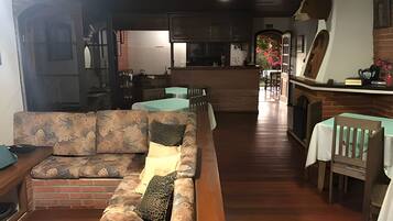 Una sala de estar acogedora con un sofá, una mesa de comedor y una cocina al fondo.