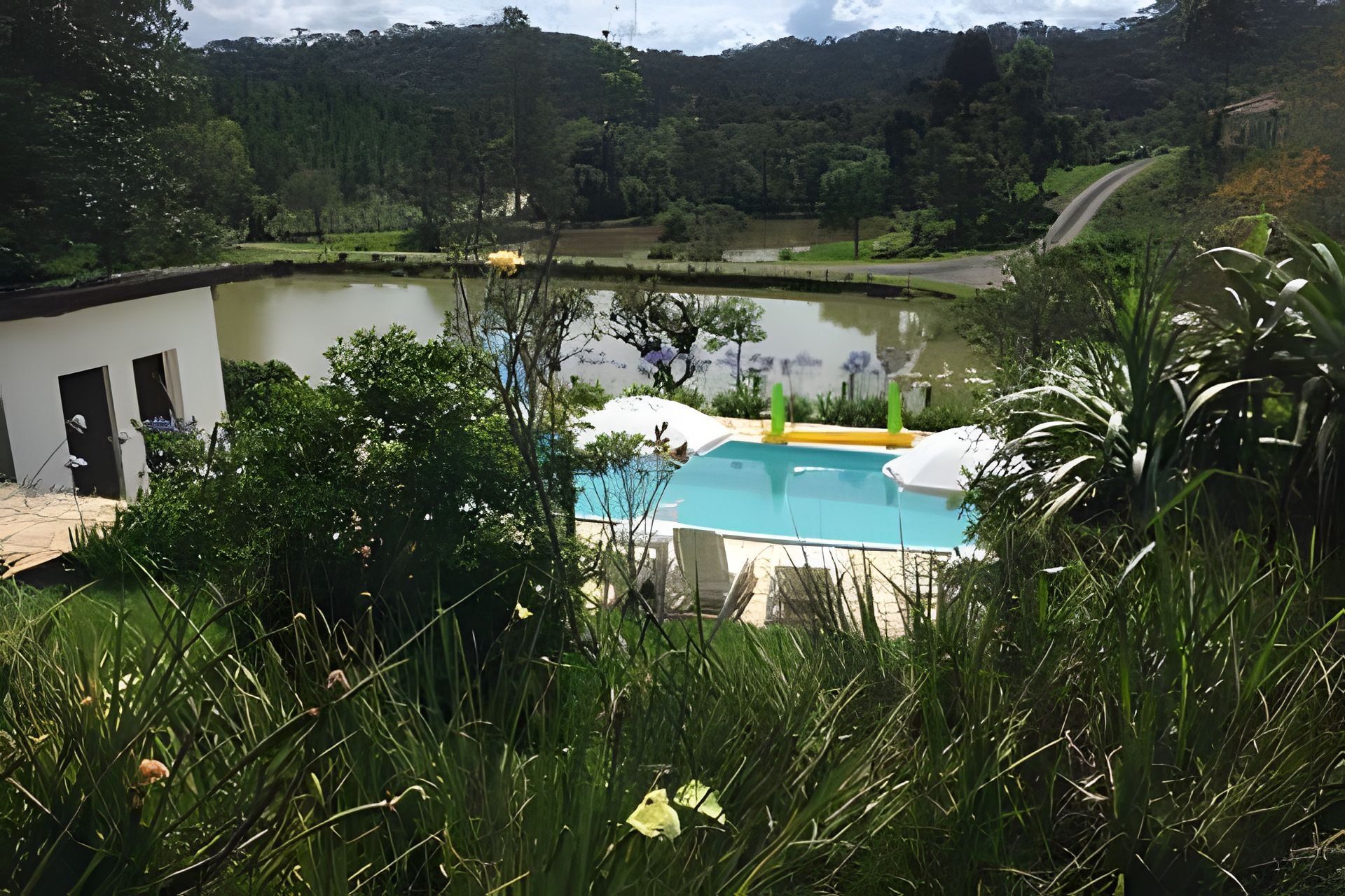 A swimming pool with a view of a lake and hills in the background.