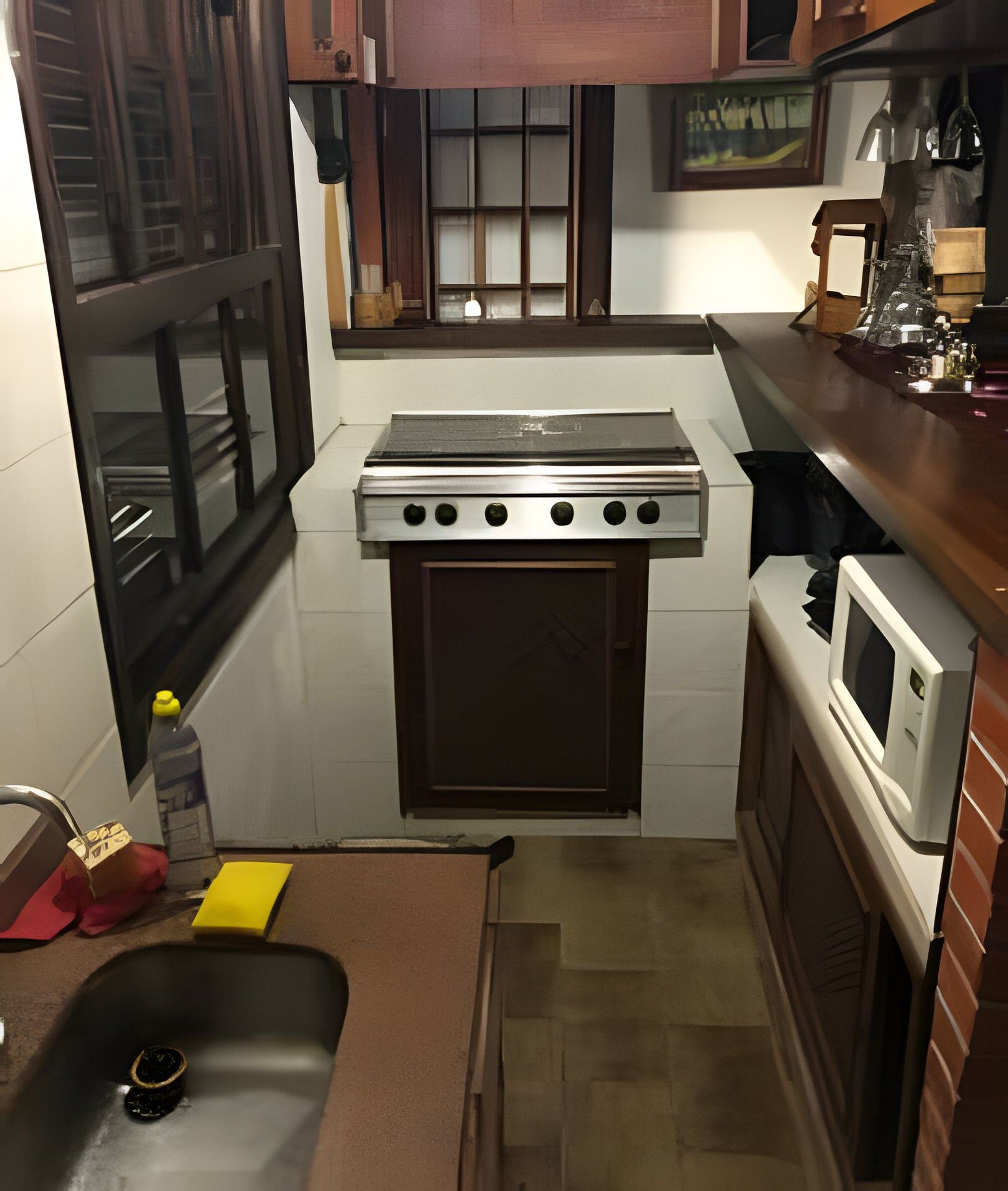 A compact kitchen with a stove, oven, microwave, and sink.