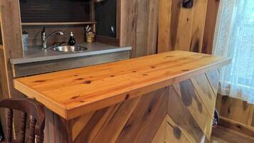 Una cucina in legno con isola integrata, un lavello e un arredamento rustico.