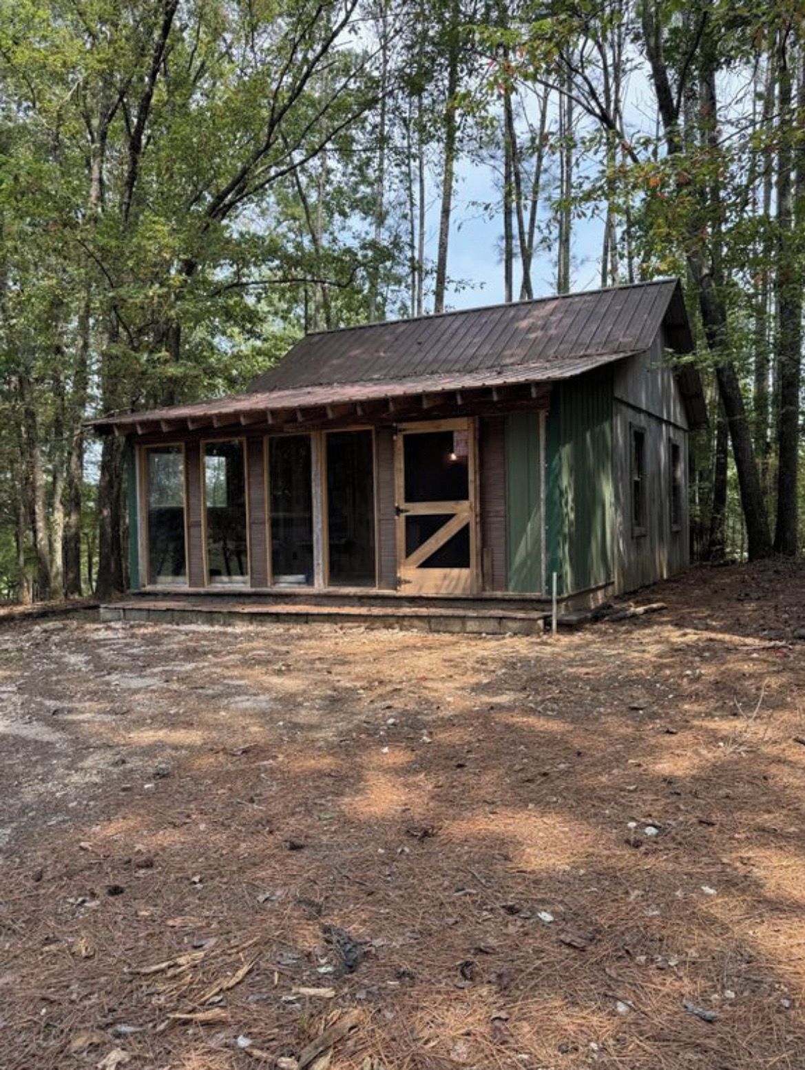 Un rustico chalet con tetto in metallo, ampie finestre e un pontile in legno.