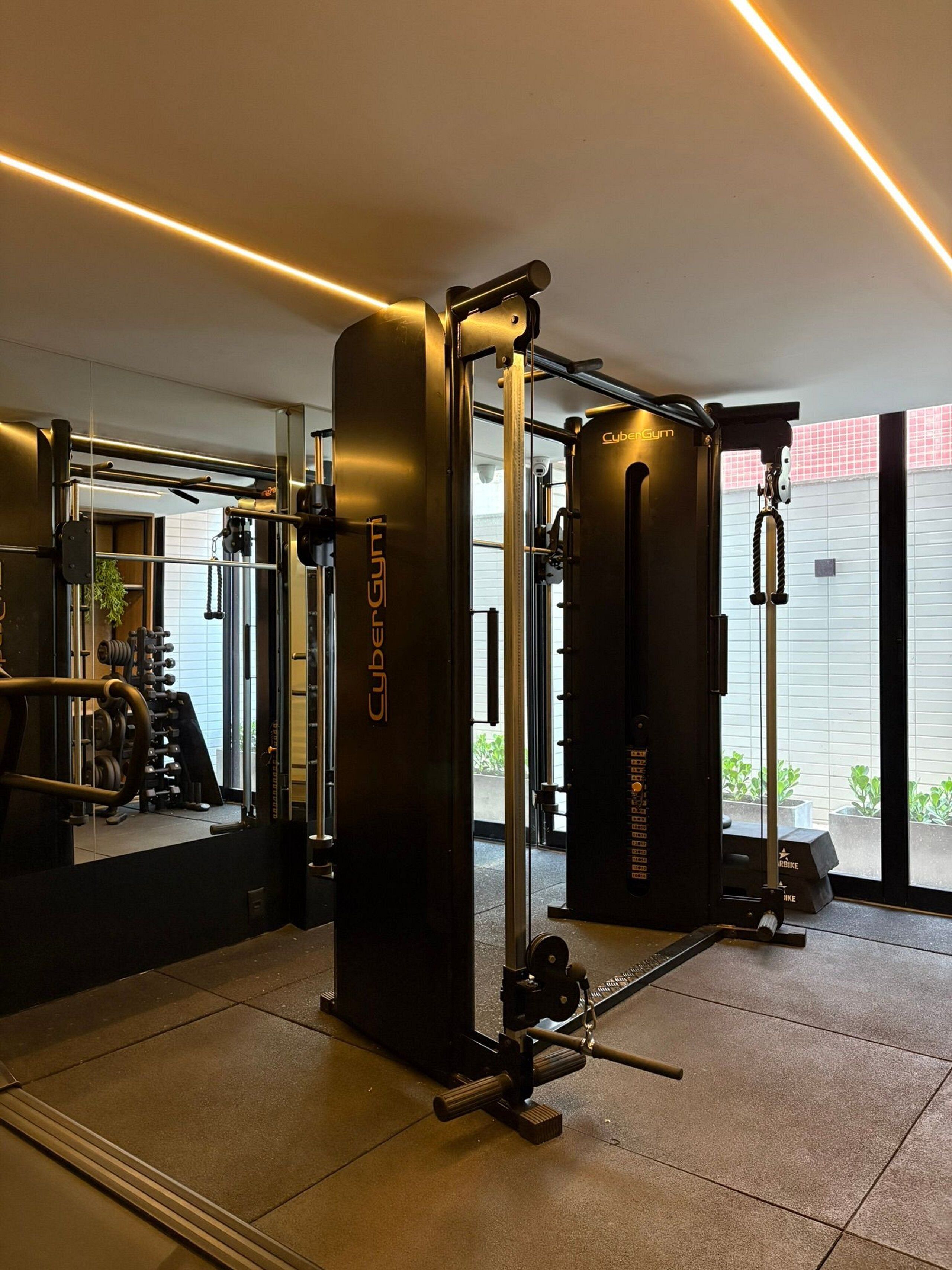 A gym with a squat rack, weight bench, and various exercise machines.
