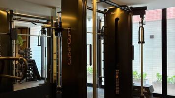 A gym with a squat rack, weight bench, and various exercise machines.