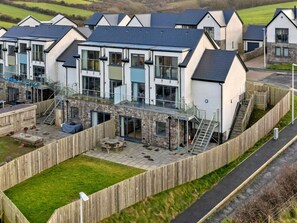 A modern residential complex with multiple houses, each featuring a balcony and a stone facade. - Stunning Broad Haven Beach House (Haverfordwest)