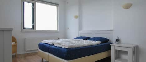 2 habitaciones, tabla de planchar con plancha y muebles diferentes