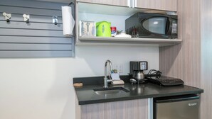 A compact kitchenette with a microwave, coffee maker, and a small sink. - Kitchenette room with Queen bed and murphy bunk beds (Telluride)