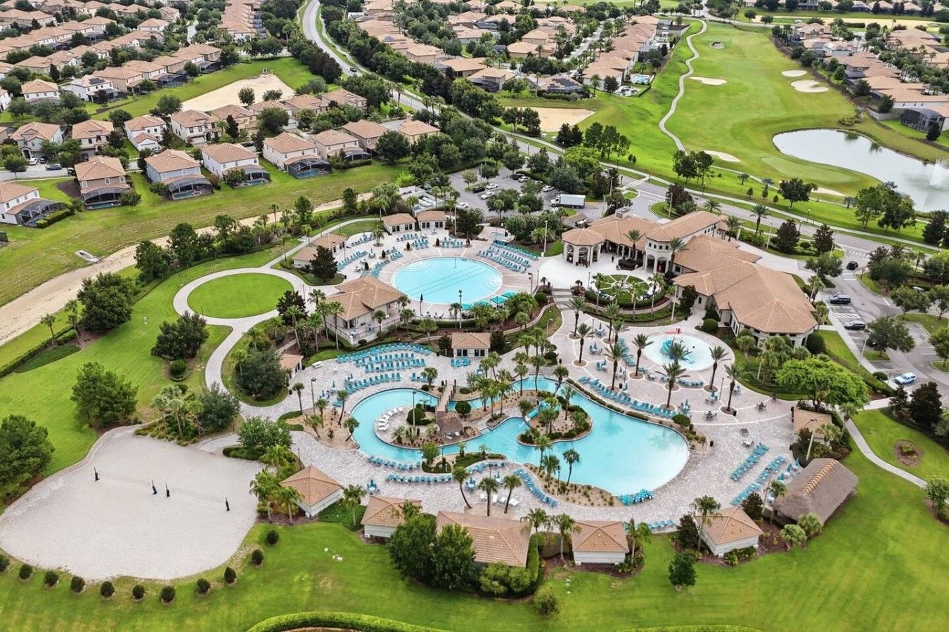 A golf course with multiple swimming pools and a clubhouse.