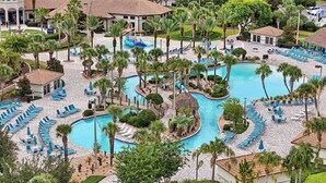 Ein Resort mit mehreren Swimmingpools, Liegebereichen und Palmen.