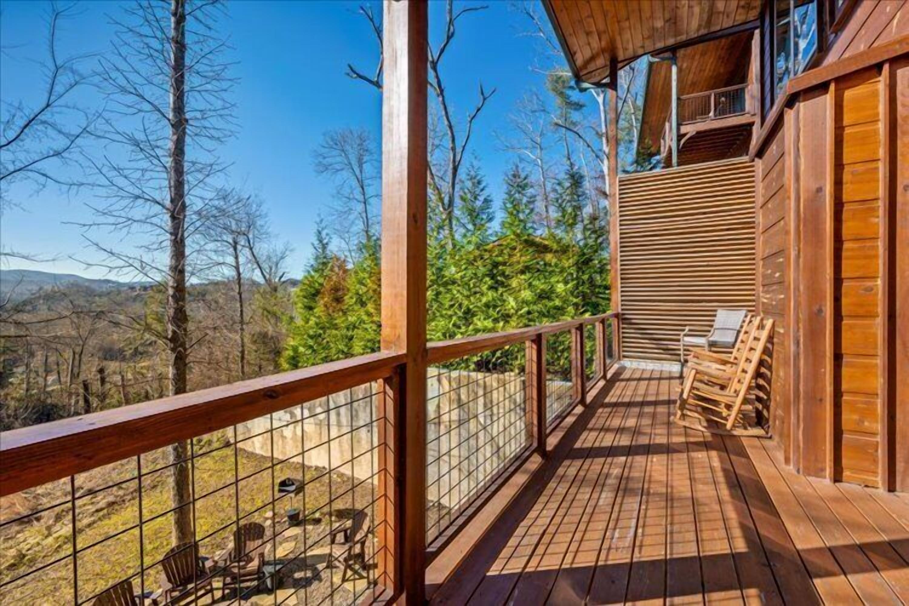 A wooden deck with a railing, a chair, and a table.