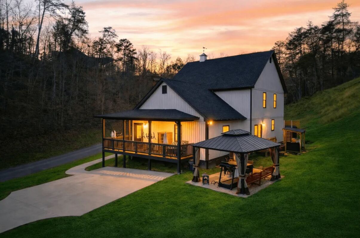 A two-story house with a porch, a covered patio, and a well-maintained lawn.