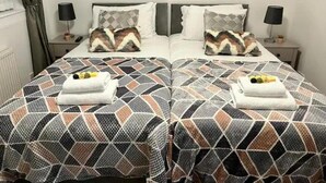 Ein Doppelbett mit gemusterten Betttextilien und zwei Handtüchern auf jeder Seite.