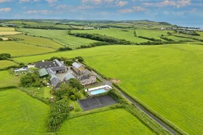 Propiedad rural con varias construcciones, incluyendo una casa principal, un granero y una zona de piscina.