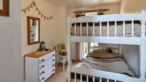 A bunk bed room with a dresser, a mirror, and a small chair. - Scenic Snowdonia Border Cottage for 4 (Bude)