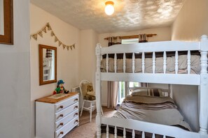 A bunk bed room with a dresser, a mirror, and a small chair. - Scenic Snowdonia Border Cottage for 4 (Bude)