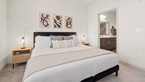 A bedroom with a bed, nightstands, a headboard, and wall art. - 2BR Desert Getaway - Pool, King Beds, Hot Tub, Gym (Tempe)