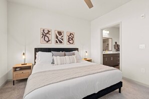 A bedroom with a bed, nightstands, a headboard, and wall art. - 2BR Desert Getaway - Pool, King Beds, Hot Tub, Gym (Tempe)