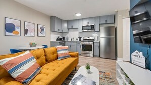 Un appartement moderne comprenant un salon, une cuisine et un coin repas.