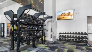 Ein Fitnessraum mit Hantelgestell, Kettlebells und Kurzhanteln.