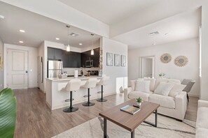 Um espaço de estar moderno com cozinha, sala de jantar e área de estar.