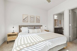 Ein Schlafzimmer mit Bett, Nachttischen, einem Kleiderschrank und einem Spiegel.