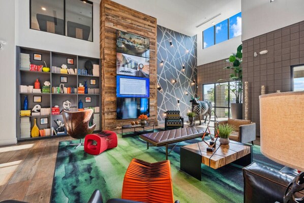 Uma sala de estar moderna com estante, TV de tela plana, design de parede único e área de estar com mesinha de centro.