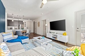 A modern living room with a sofa, coffee table, and a flat-screen TV. - Tempe's Finest - King Beds, Pool & Prime Location! (Tempe)