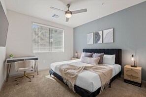 A bedroom with a bed, bedside tables, a desk, a chair, and a ceiling fan. - Tempe's Finest - King Beds, Pool & Prime Location! (Tempe)
