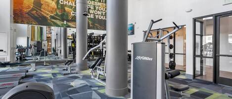 A gym with exercise equipment, motivational posters, and a patterned floor.