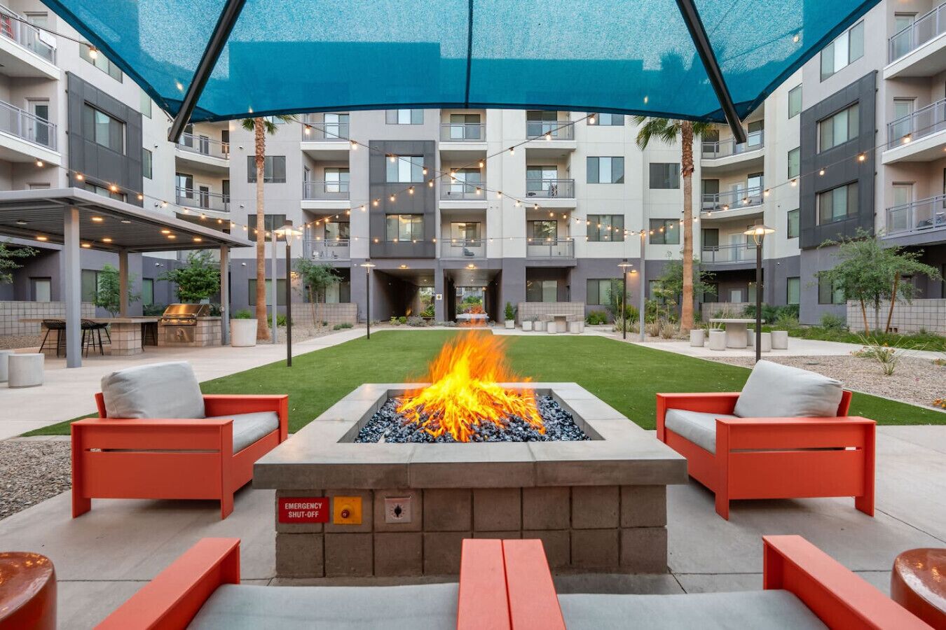 An outdoor patio with a fire feature, seating, and a covered area.