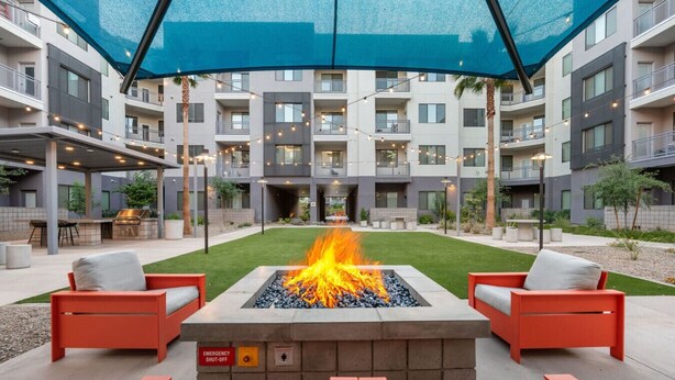Une terrasse extérieure dotée d’un foyer, de sièges et d’un espace abrité.