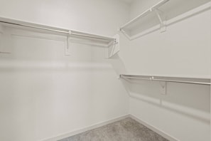 A corner of a room with white walls and a gray carpet. There are two metal shelves mounted on the wall, one on each side of the corner. - Tempe Oasis - King Beds, Pool, Gym, DT Tempe & ASU (Tempe)