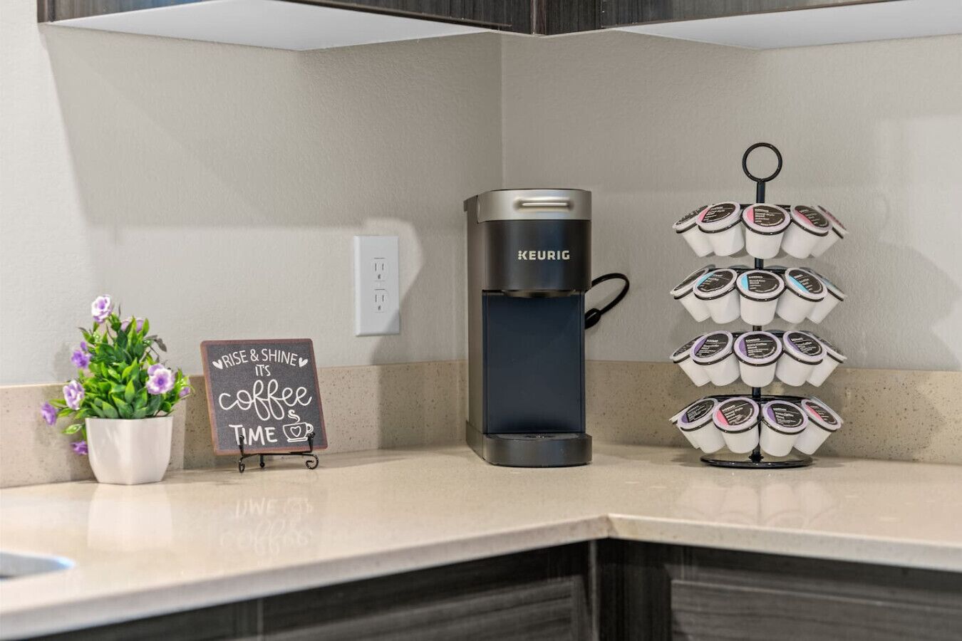 A coffee maker, a coffee cup holder, and a sign with a coffee theme.