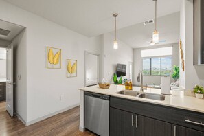 A modern kitchen with a dishwasher, double sink, and a large window. - Luxury Tempe 1BR - Pool, Hot Tub, Gym, King Bed (Tempe)