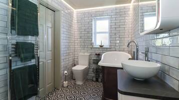 A bathroom with a glass shower enclosure, a toilet, a bathtub, and a sink.
