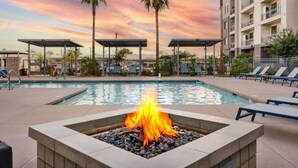 Ein Pool mit Liegestühlen und einer Feuerstelle.