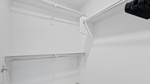 A corner of a room with white walls, a door, and a corner shelf unit. - Desert Oasis - Pool, Gym, Courtyard - King Bed (Tempe)