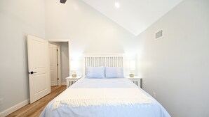 Una camera da letto con un letto, comodini e una porta.