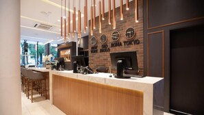 A modern reception desk with a wooden counter and a brick wall with city names. - Hotel Centro Europeu (Curitiba)