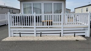 A mobile home with a white deck and a covered porch.