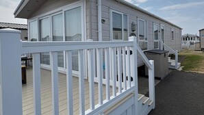 A mobile home with a deck and a covered porch.