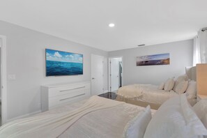 Ein Schlafzimmer mit zwei Betten, einer weißen Kommode und zwei Bildern an den Wänden.