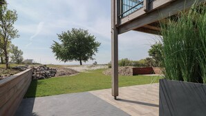 Un sendero pavimentado que conduce a un edificio, con un árbol grande al fondo.