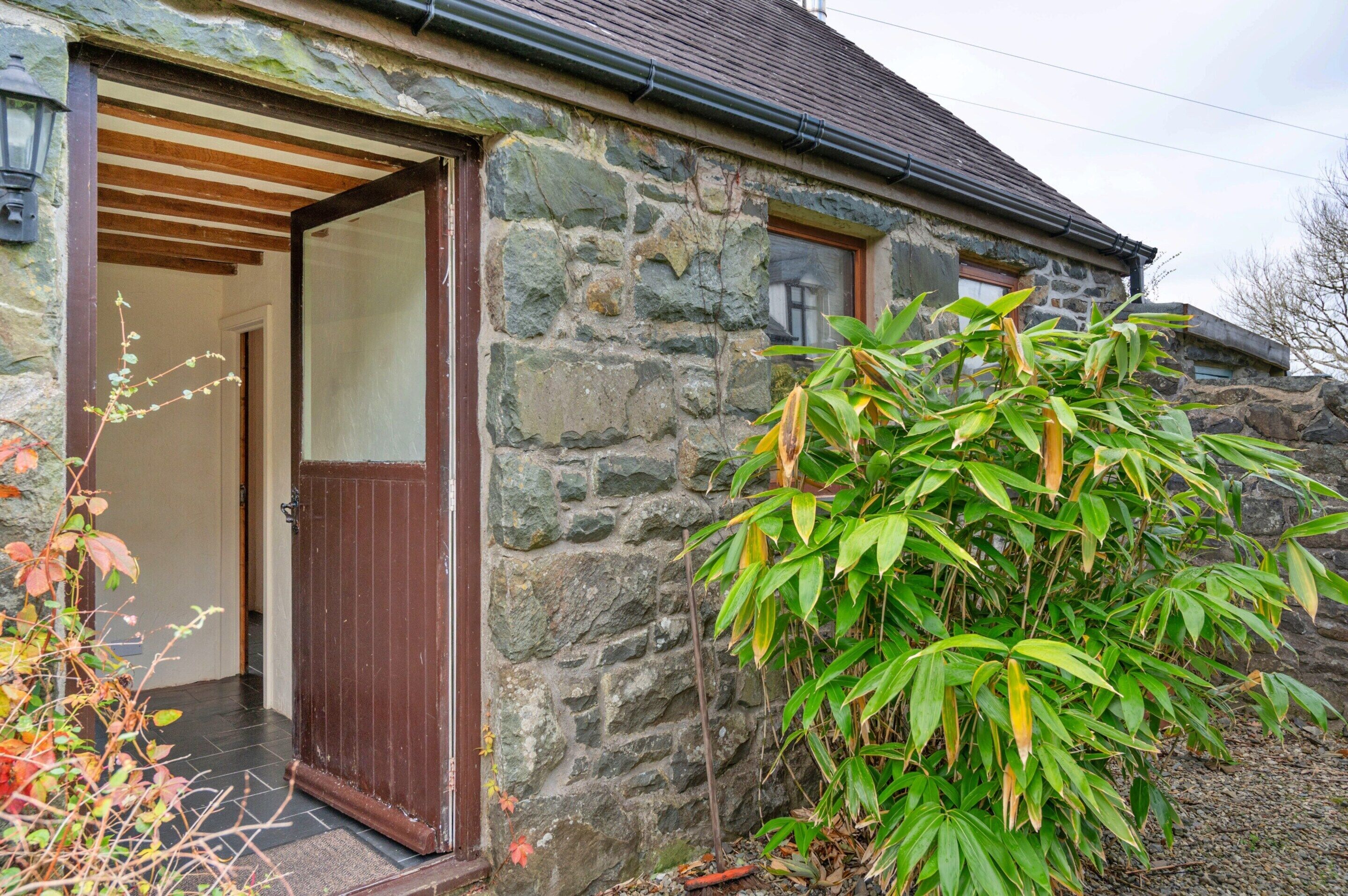 A stone building with a wooden door and a small window.