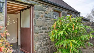 A stone building with a wooden door and a small window.