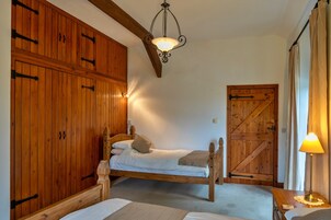 Un dormitorio con una cama de madera, un armario, una puerta y una lámpara.